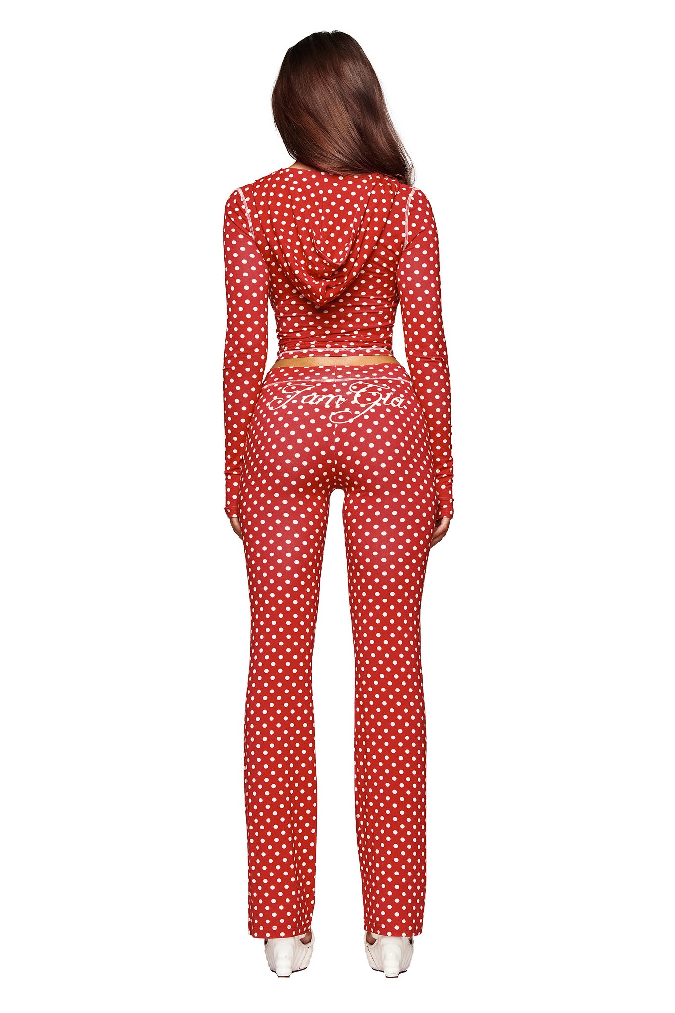 A woman with long brown hair poses against a white background wearing the I.AM.GIA BLARE HOODIE - RED POLKA DOT, showcasing its playful style with "Coca-Cola" on the back.