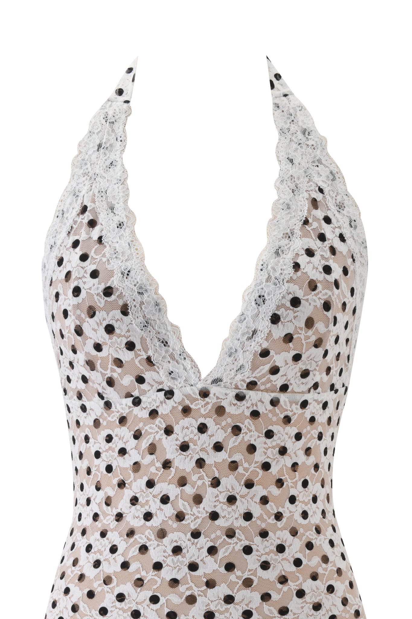 A close-up of the GEM MINI DRESS - WHITE by I.AM.GIA, a sleeveless halter-neck mini dress with a deep V-neckline, featuring black polka dots over nude lining and white lace for an elegant, modern style.