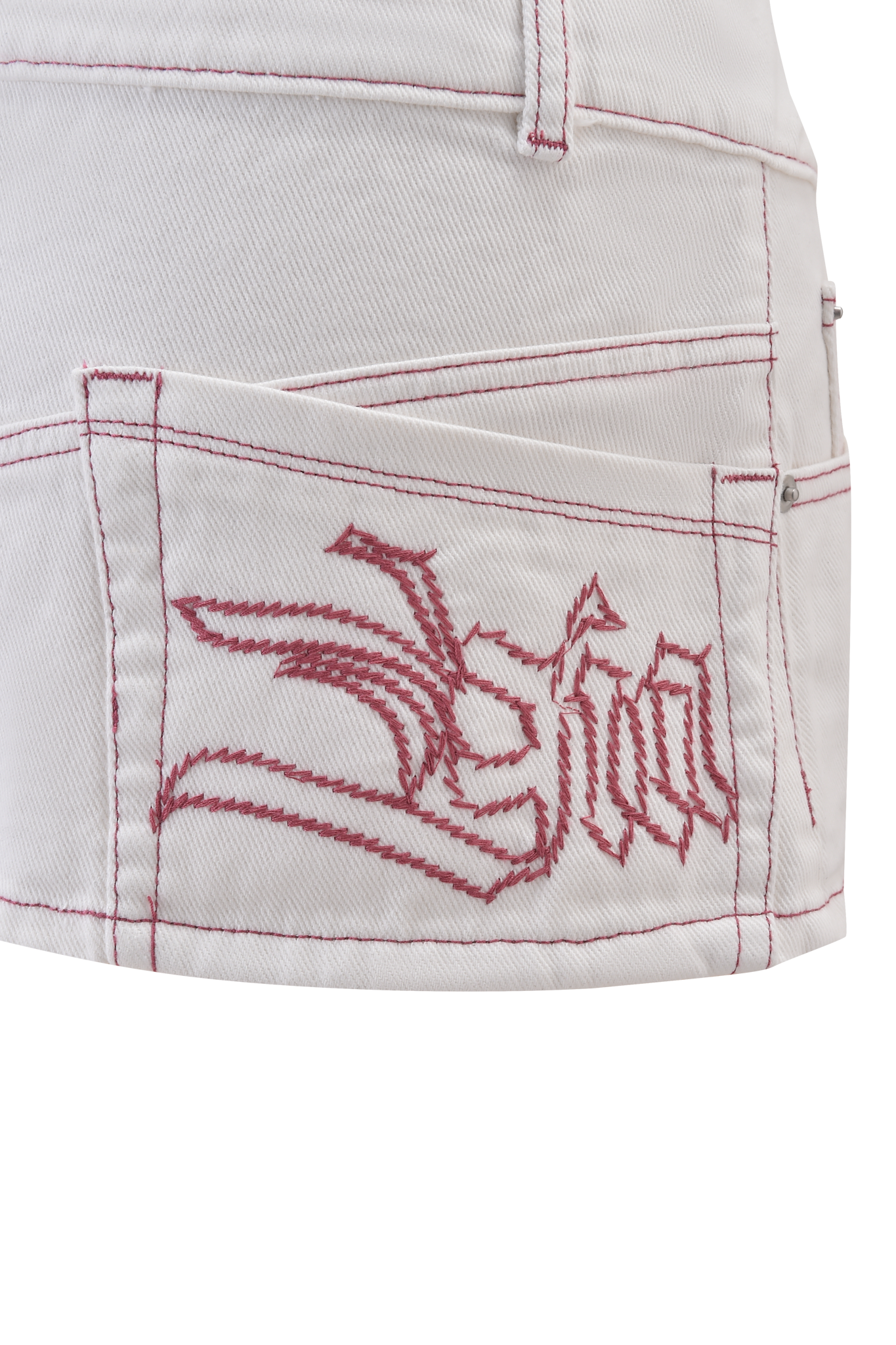 Close-up of the MOXIE DENIM MINI SKORT by I.AM.GIA in white, featuring hot pink contrast stitching, an embroidered "Fun" design with stylized shapes, and made from 100% cotton for comfort and style.