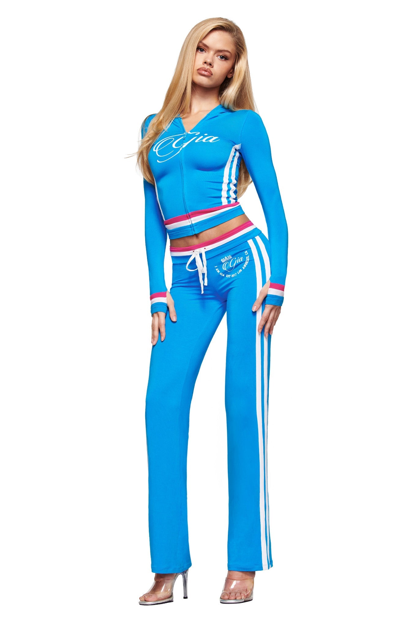 A woman in I.AM.GIA's BLARE STRIPED TRACKPANT in sky blue.