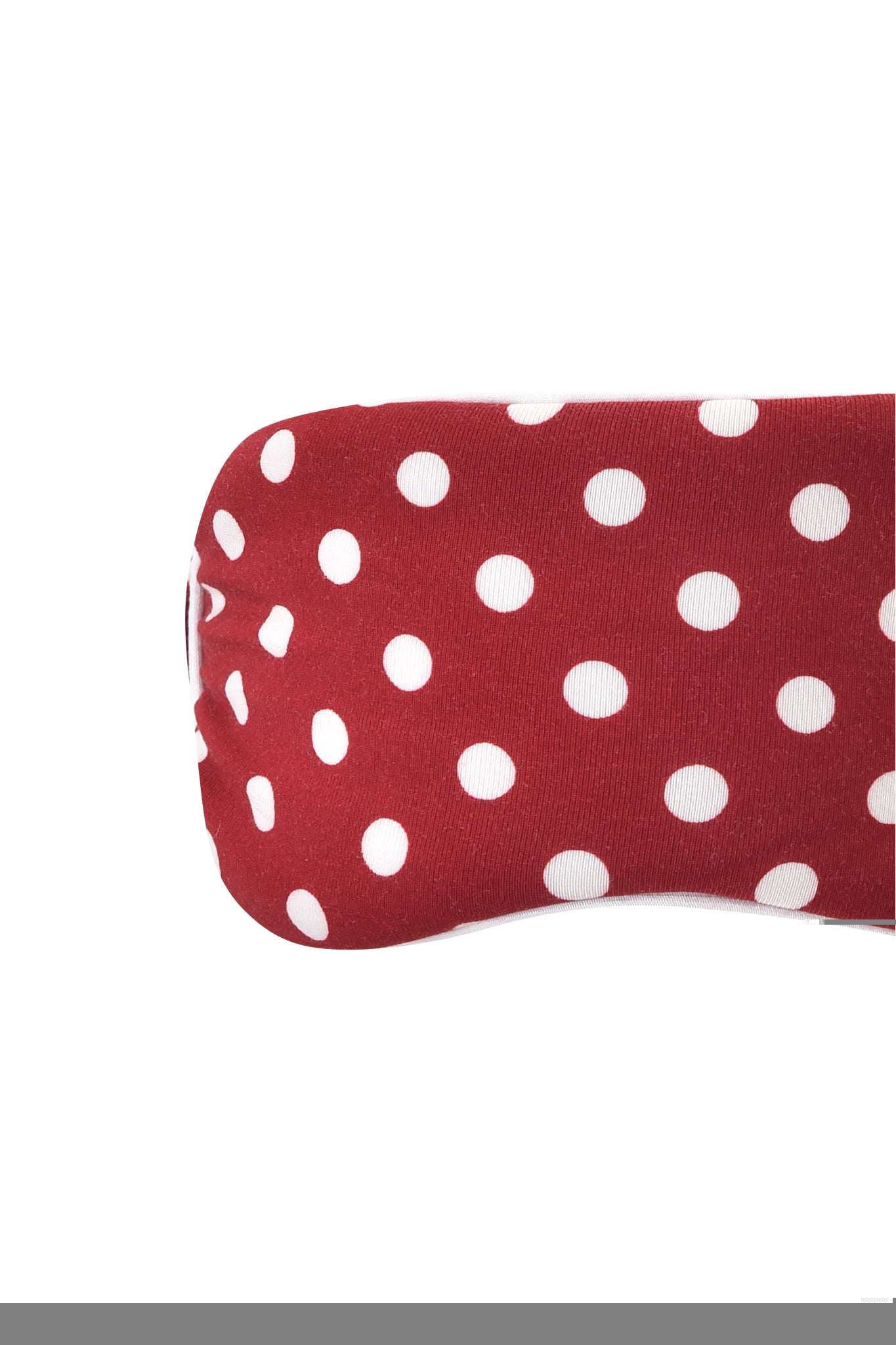 A close-up of the I.AM.GIA MELANIE SLEEPWEAR - RED POLKA DOT shows its red fabric with white polka dots and part of a rounded piece, likely a sock or slipper, set against a white background.