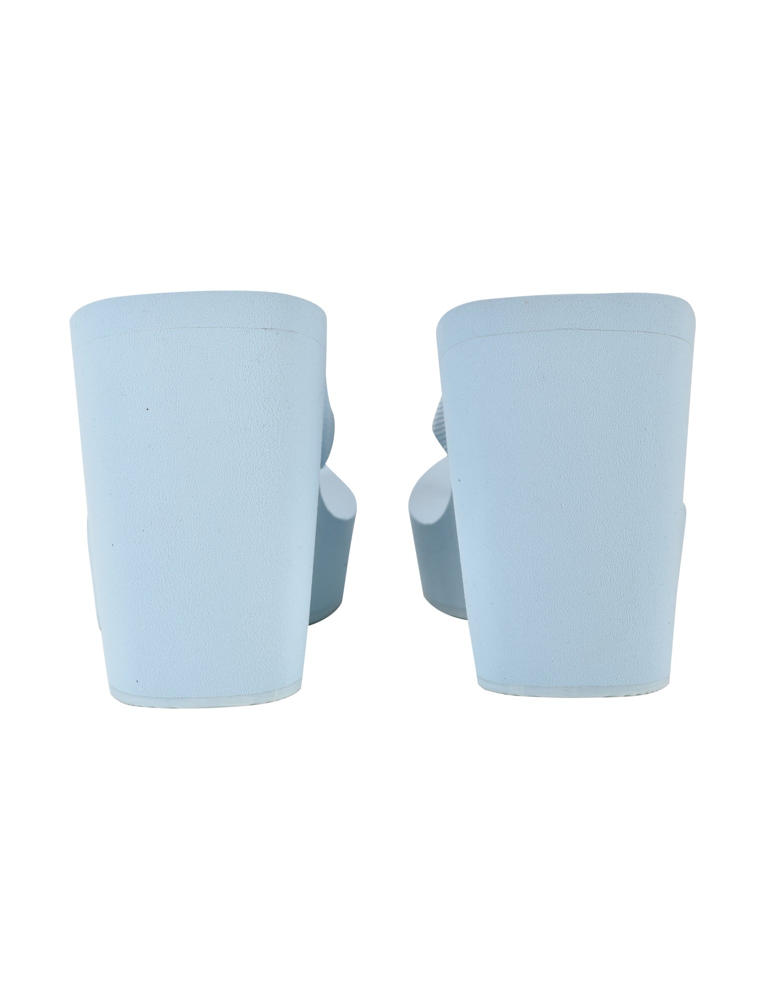 Rear view of the SHELBY FLIP FLOP - BLUE: BABY BLUE from I.AM.GIA showcasing a thick platform heel. The sandals exhibit a smooth, minimalist design, highlighting the back of the heels.