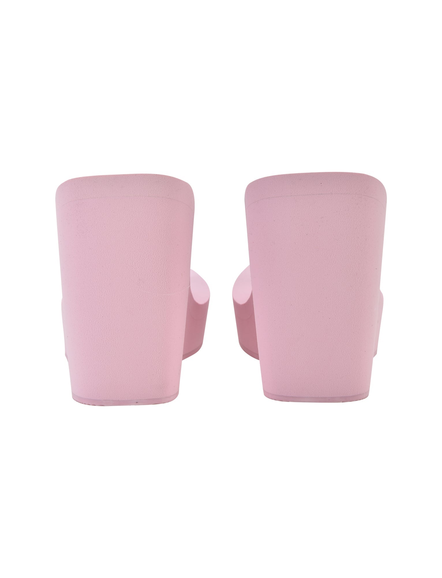 A rear view of a pair of I.AM.GIA SHELBY FLIP FLOP in baby pink showcases platform sandals with open heels and toes. The shoes feature thick, high soles and have a smooth texture, displayed standing upright, side by side against a white background.