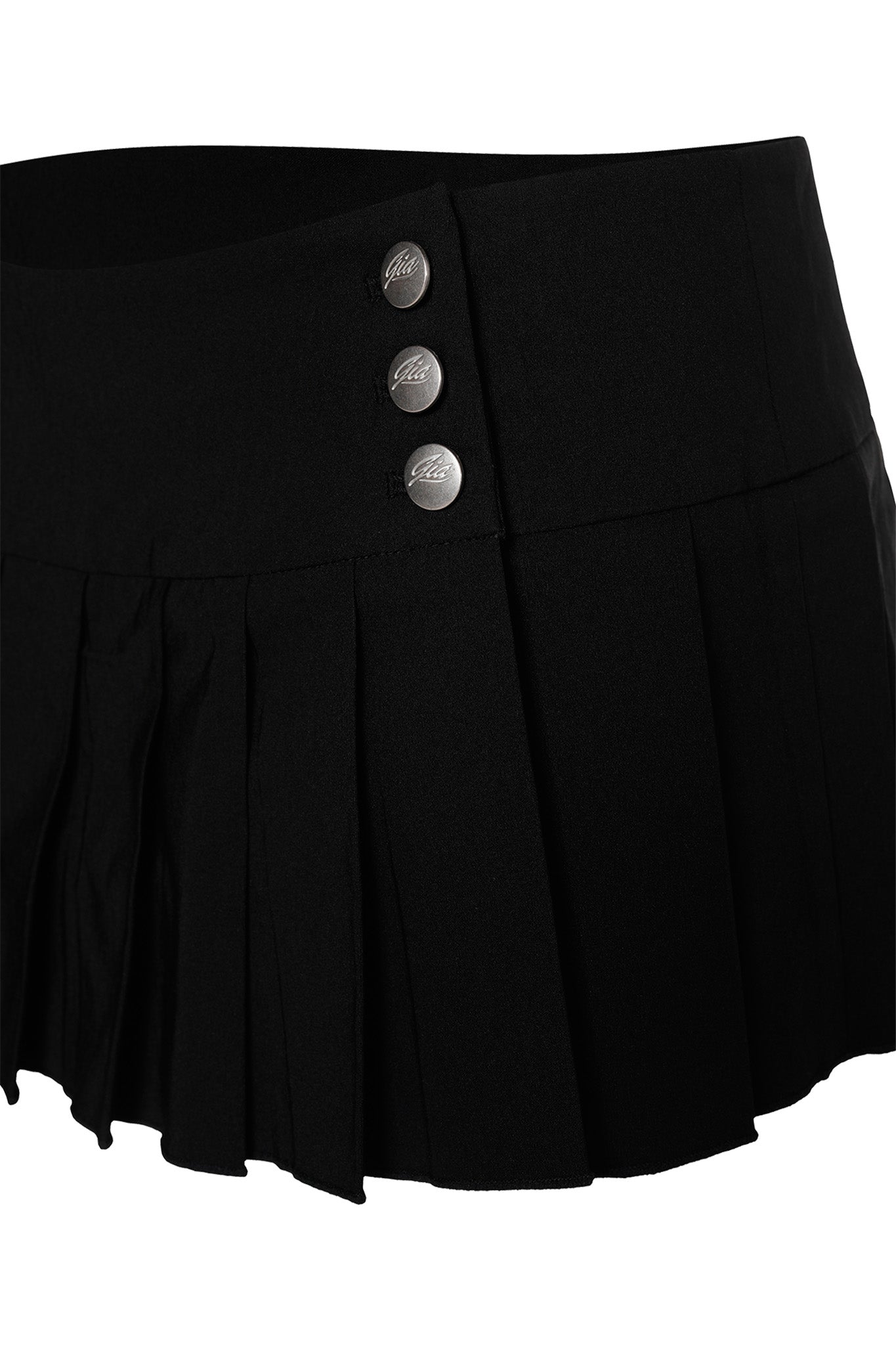 The REMINI SKORT - BLACK by I.AM.GIA features a high waistline and a fitted top section adorned with three silver buttons on the side. It transitions into pleats that create a flared look toward the bottom, embodying the classic charm of a pleated mini skirt.