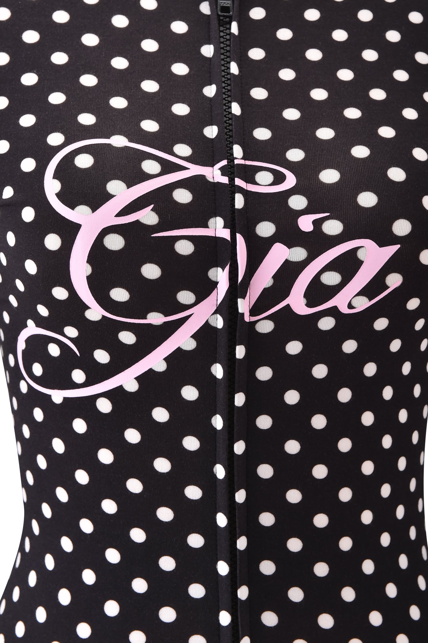 Close-up of the BLARE HOODIE - BLACK POLKA DOT by I.AM.GIA, featuring white polka dots, a center zipper, and “Gia” in bold pink cursive across the chest.