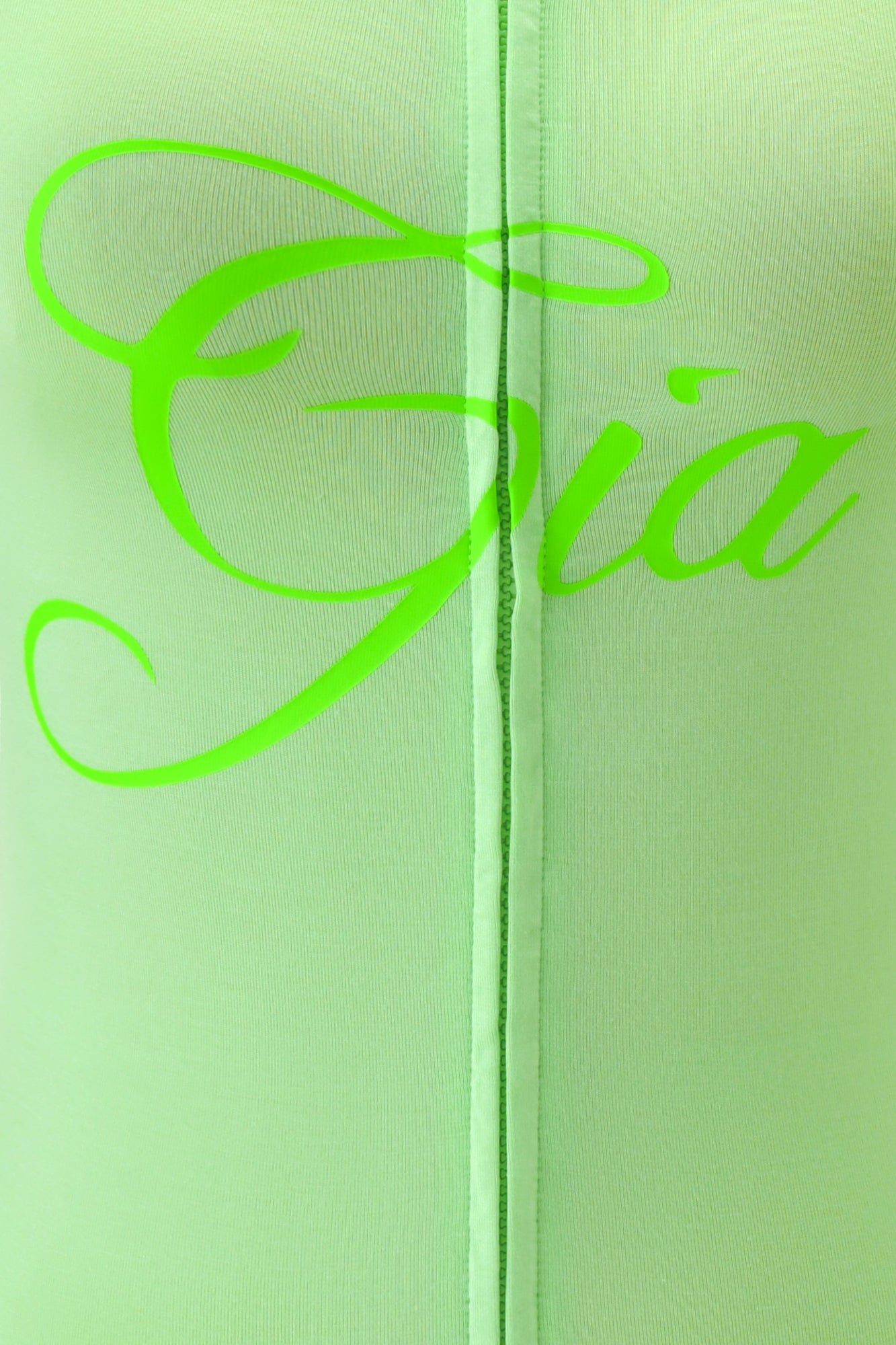 Close-up of light green fabric from the I.AM.GIA BLARE HOODIE - NEON GREEN, featuring "Gia" in large, cursive neon green letters and a vertical seam running down the center beneath the bold logo.