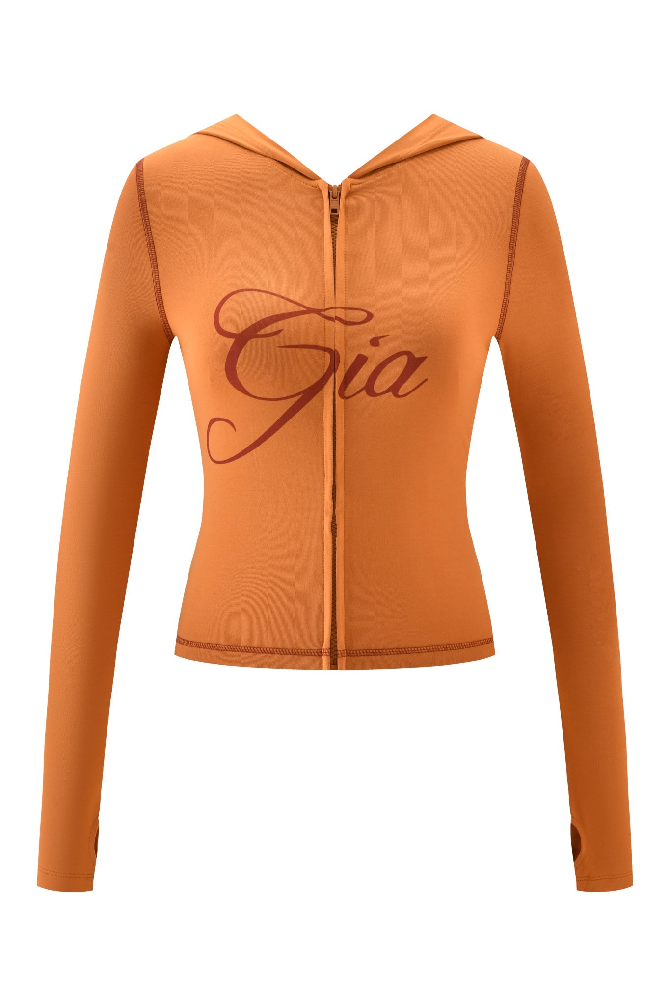 The BLARE HOODIE - PUMPKIN by I.AM.GIA is a fitted, long-sleeve zip-up hoodie with bold red “Gia” cursive, stylish thumb holes, and a cozy pumpkin spice color.