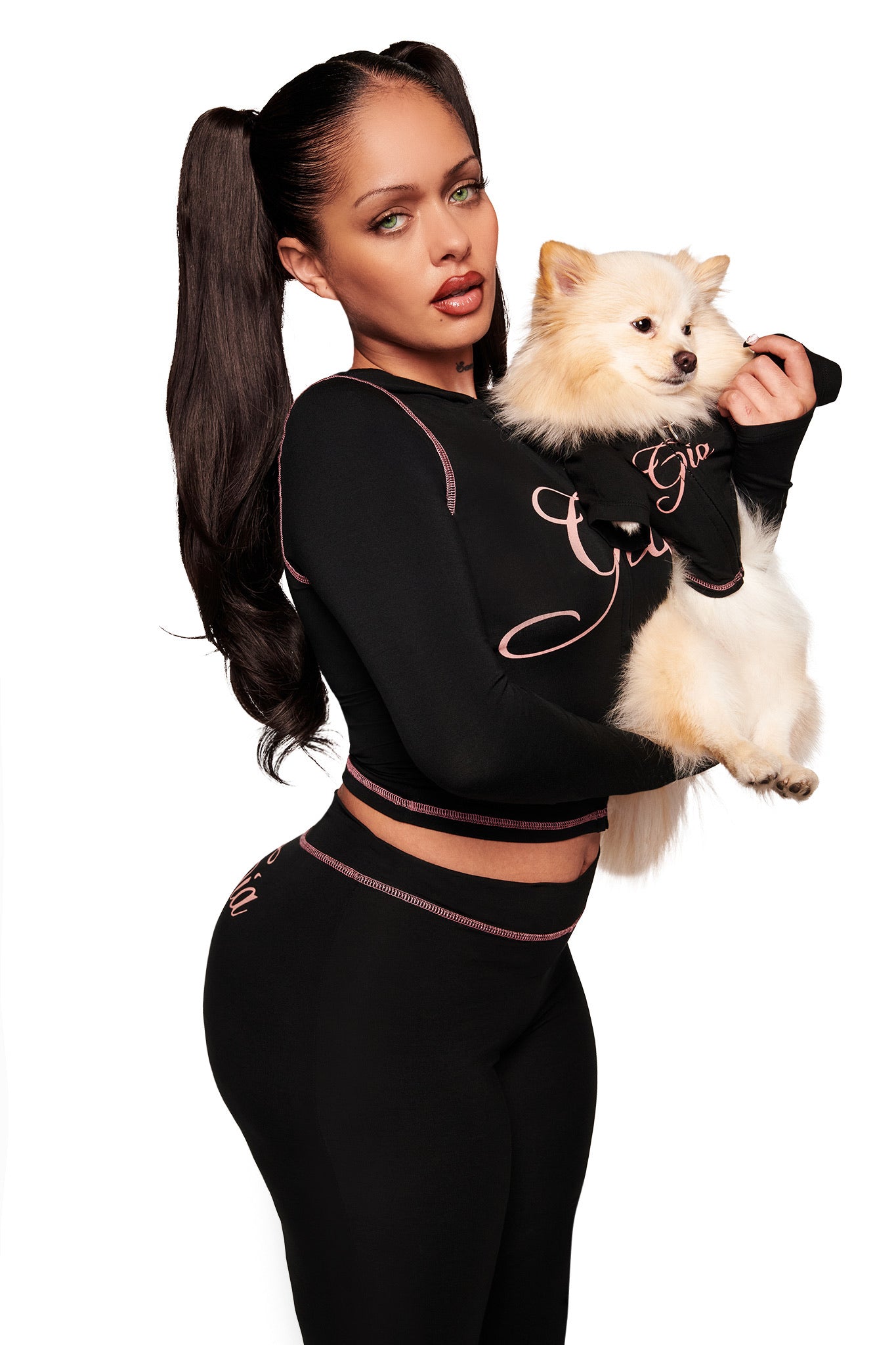 A woman holds her dog, both wearing matching I.AM.GIA outfits—the BLARE BEST FRIEND DOG HOODIE in black.