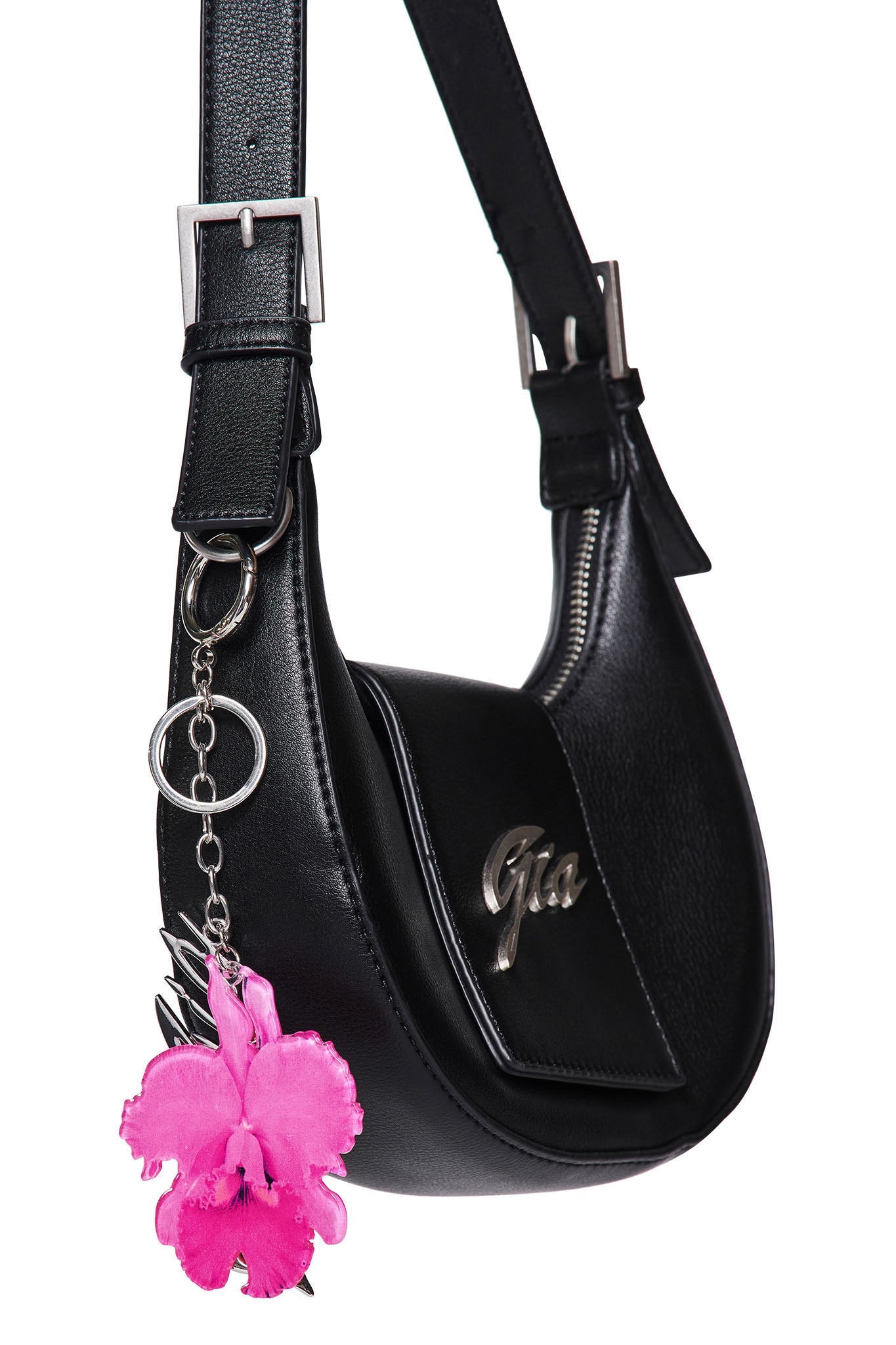 A black leather shoulder bag by I.AM.GIA with silver hardware, a GIA metal logo on the front, and an ORCHID KEYCHAIN - NEON PINK hanging from the strap.