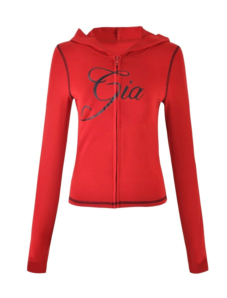 The BLARE HOODIE - RED by I.AM.GIA features long sleeves, a hood, and "Gia" in black cursive across the chest, blending comfort and style for an essential everyday look.